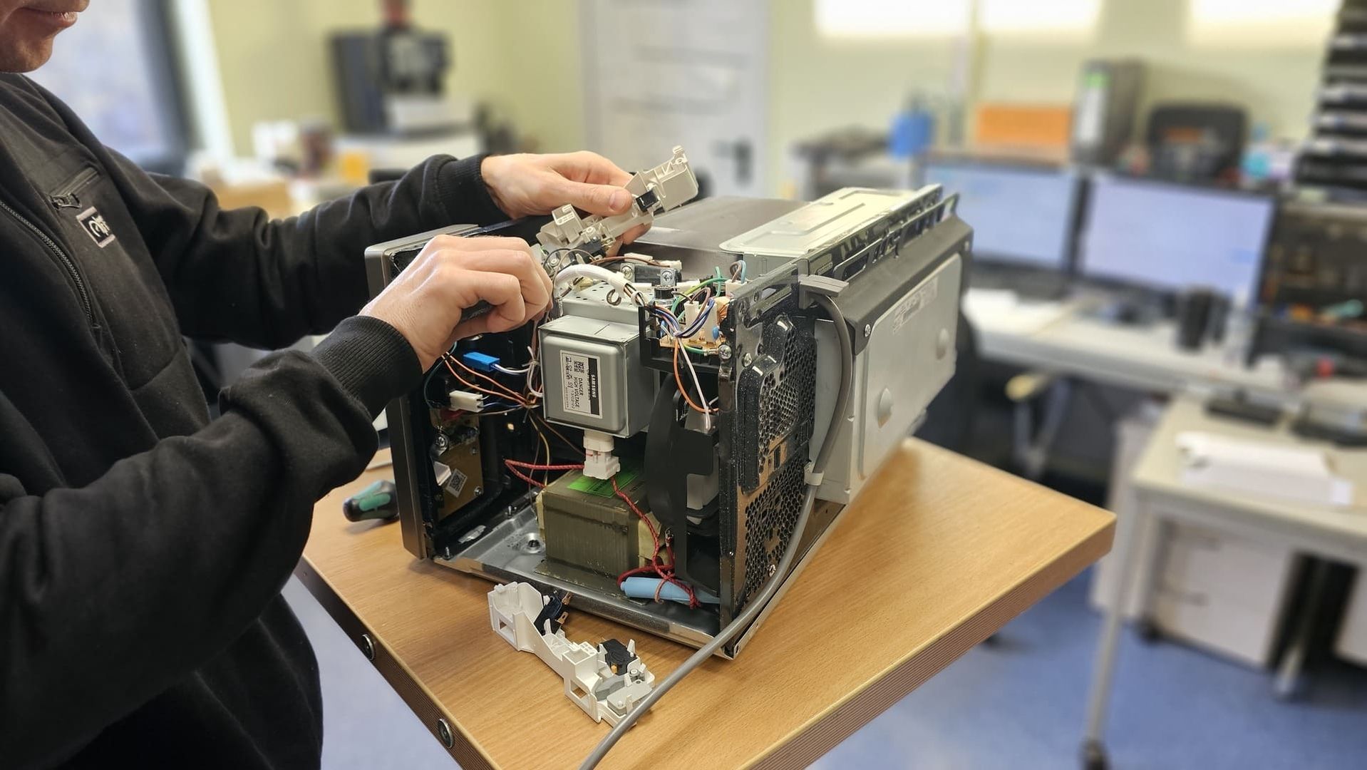 Eine Person repariert eine Mikrowelle