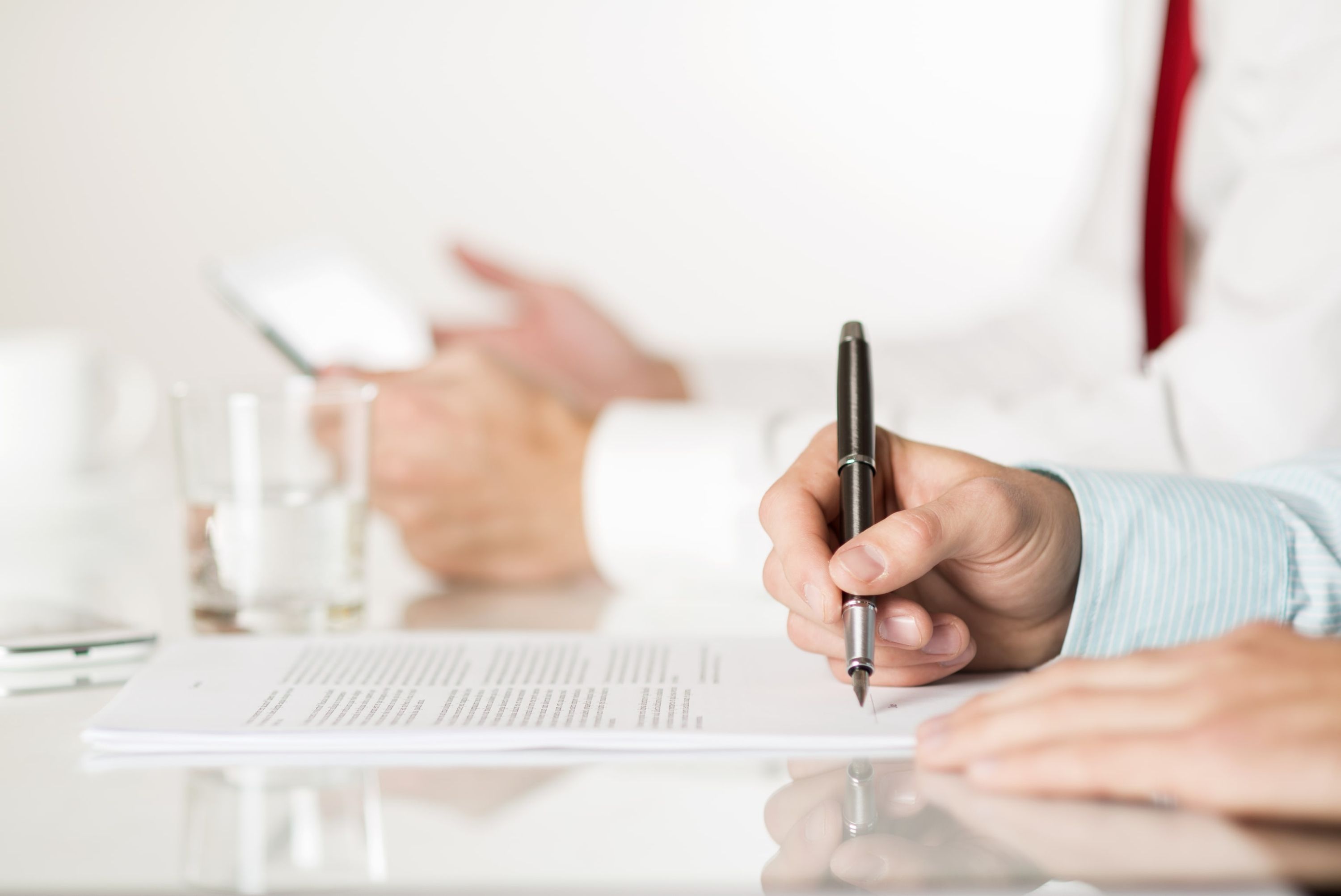 Mann in einem Schulungsraum, der mit einem Stift Seminarinhalte auf einem Dokument festhält