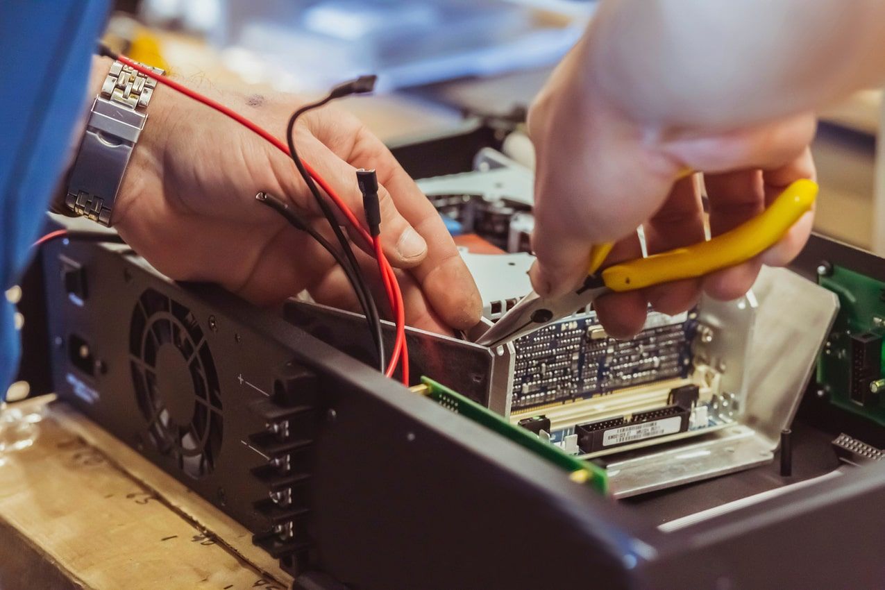 Ein Techniker repariert einen Computer und hält eine Zange in der Hand